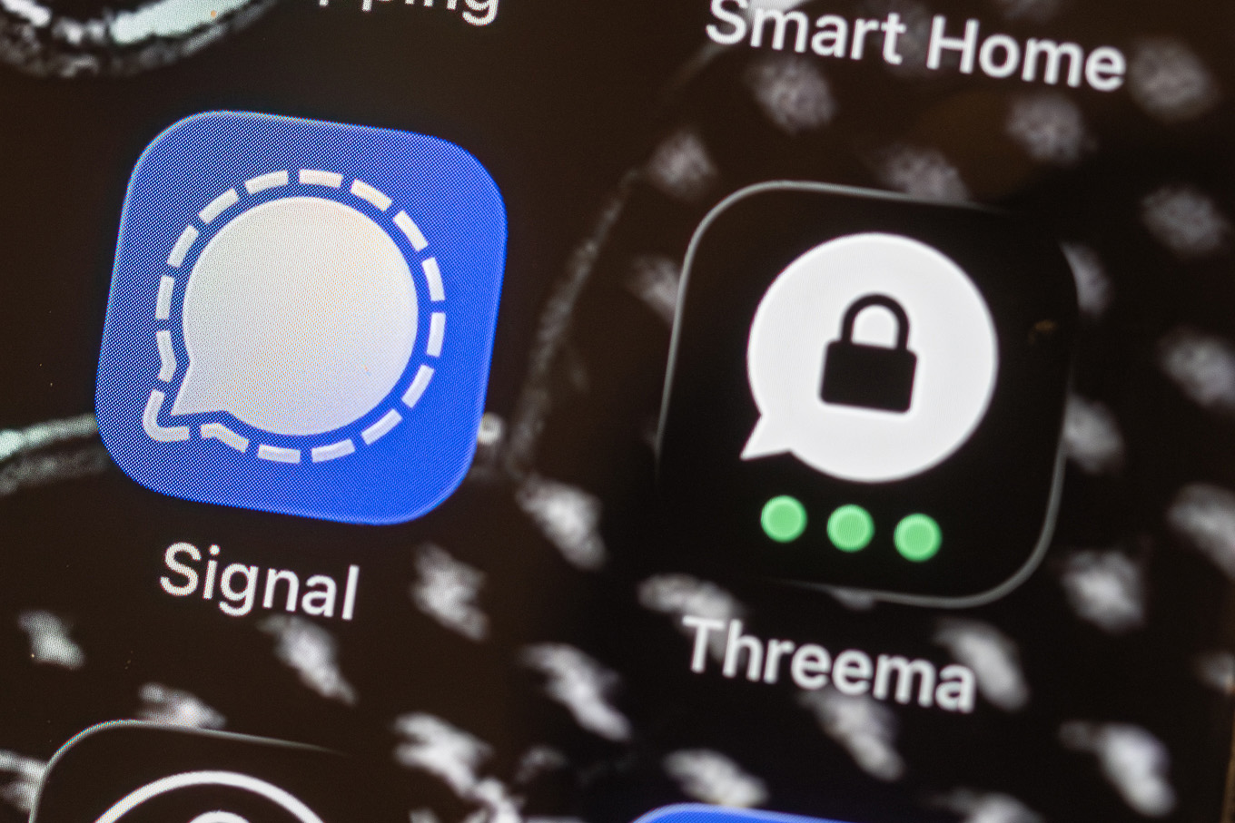 Nahaufnahme eines Smartphone-Displays mit App-Symbolen für die Messenger „Signal“ und „Threema“. Unter den Icons sind die App-Namen „Signal“ und „Threema“ lesbar.